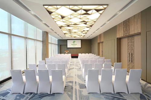 a conference room with white chairs and a screen at Holiday Inn Cebu City by IHG in Cebu City