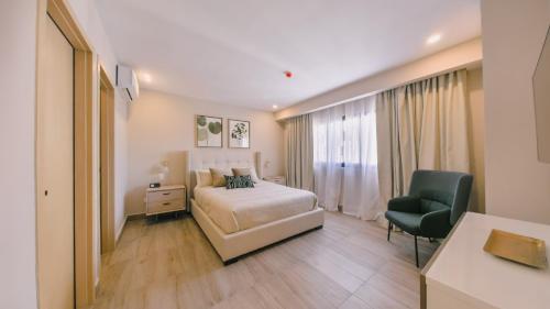 een slaapkamer met een bed, een bureau en een stoel bij Fully Serviced Apartment at Regatta Living II - 905 in Santo Domingo
