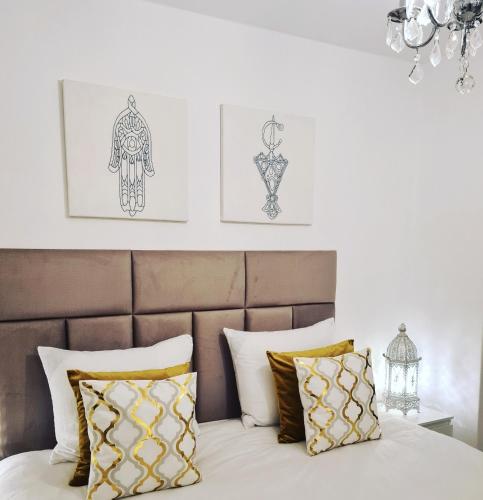 a bedroom with a bed with gold and white pillows at Amberdi Apartment Amsterdam Schiphol Airport in Hoofddorp