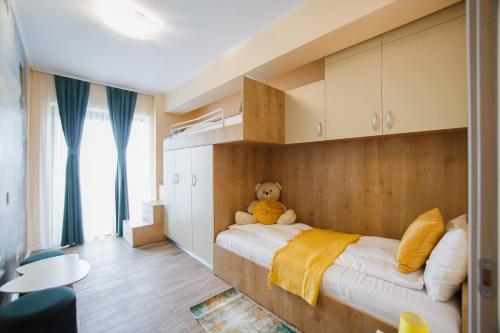 a bedroom with a teddy bear sitting on a bed at Grand Panorama City Views in Oradea