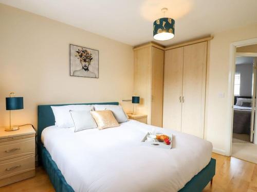 a bedroom with a large white bed with a tray on it at Wisteria Place in Tiptree