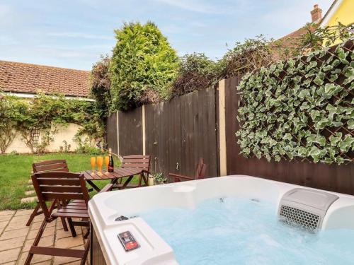 una bañera de hidromasaje en un patio junto a una valla en Wisteria Place, en Tiptree