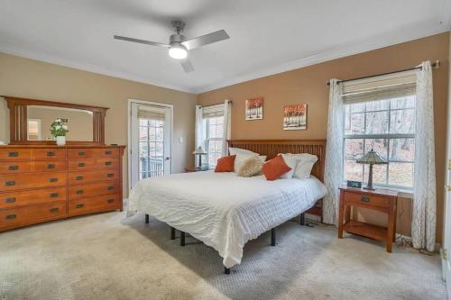 Schlafzimmer mit einem Bett, einer Kommode und Fenstern in der Unterkunft Family Fun Getaway near Cascade Lake in Warwick NY in Warwick