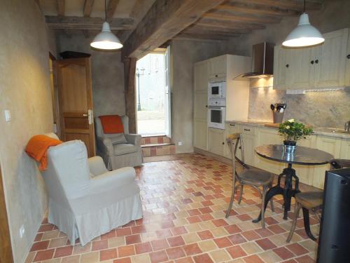 a kitchen with a table and chairs in a room at Gîte de charme Floréales Les Iris in Asnelles