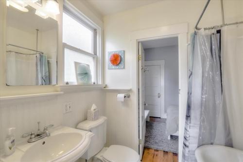 ein Badezimmer mit einem Waschbecken, einem WC und einem Spiegel in der Unterkunft Light filled Condo with enclosed sunny backyard in Oakland