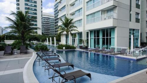 una piscina con tumbonas y un edificio en Apartamentos no Verano Stay, en Río de Janeiro