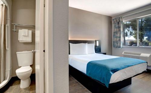 ein Schlafzimmer mit einem Bett, einem WC und einem Fenster in der Unterkunft Motel 6-Bakersfield, CA - South in Bakersfield