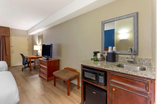 a hotel room with a sink and a bedroom at Best Western Plus Cary - NC State in Cary