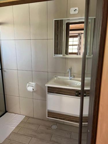 a bathroom with a sink and a mirror at Caminho do Sol in Monte Verde