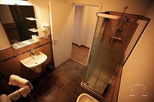 Un baño con lavabo, inodoro y ducha. en La Libra Rooms, en Cagliari