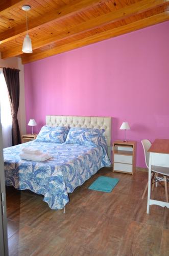 a bedroom with a bed and a pink wall at DUPLEX EXCELENTE!!! De SUSY RENTAL in Malargüe