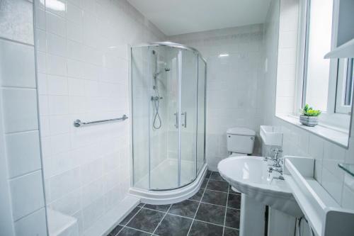 a white bathroom with a shower and a sink at Dwellcome Home Ltd 2 Bedroom 3 Bed South Shields Apartment - see our site for assurance in South Shields
