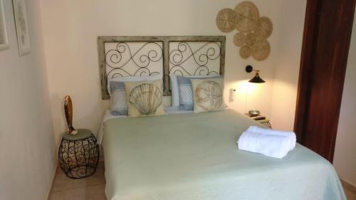 a bedroom with a large white bed with a headboard at Chalé Juliet in Pirenópolis