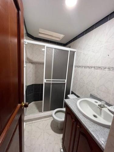 a bathroom with a shower and a toilet and a sink at Finca tres colinas in Lemos