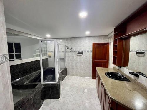 a large bathroom with a shower and a sink at Finca tres colinas in Lemos