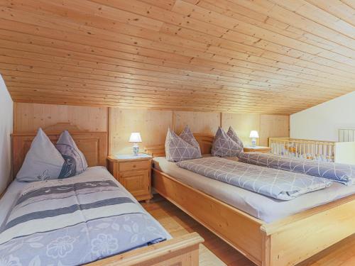 two beds in a room with wooden ceilings at Boar Hof Top 1 in Kirchberg in Tirol