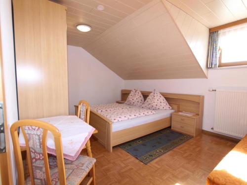 um pequeno quarto com uma cama e uma cadeira em Schlossblick em Liebenfels