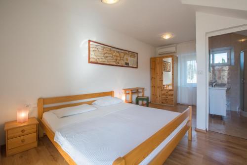 1 dormitorio con 1 cama grande con marco de madera en Holiday house with WiFi Rovinjsko Selo, Rovinj - 3431, en Rovinj