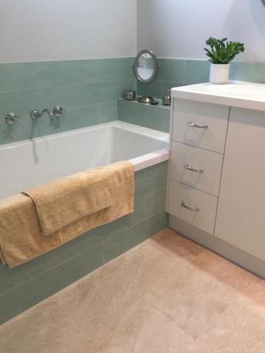 een badkamer met een bad en een wastafel bij Bird Abode in Maryborough