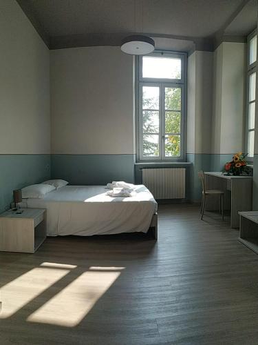 a bedroom with a white bed and a window at Casa di ALTAVILLA in Alba