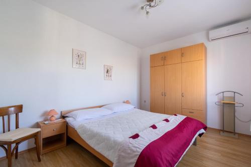 プレコにあるApartments by the sea Preko, Ugljan - 14917のベッドルーム1室(ベッド1台付)、木製キャビネットが備わります。