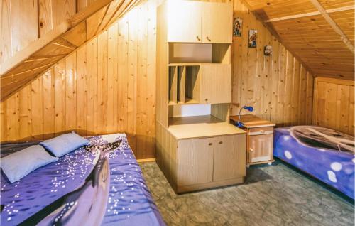 a bedroom with two beds in a wooden cabin at Cozy Home In Dabrwno With Lake View in Dąbrówno
