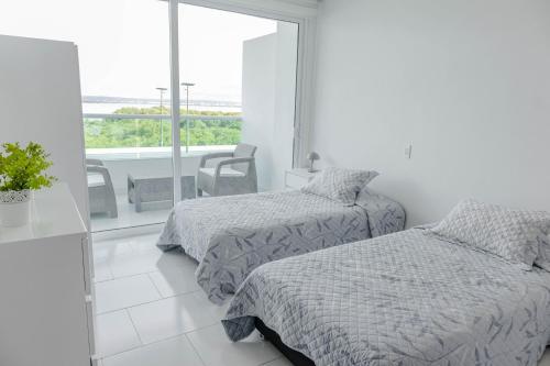 Dieses weiße Zimmer verfügt über 2 Betten und einen Balkon. in der Unterkunft apartamento 1 alcoba morros 922 rnt 132107 in Cartagena de Indias
