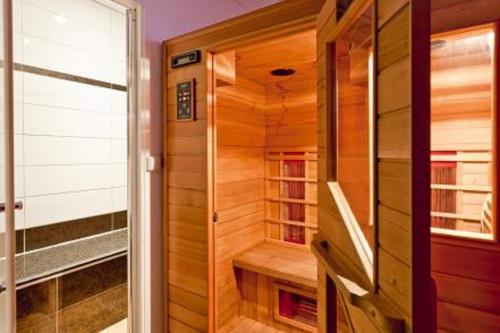 a walk in shower in a wooden room with a sauna at Par Hasard in Maffe