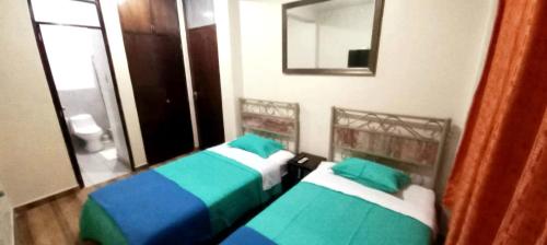2 łóżka pojedyncze w pokoju z lustrem w obiekcie Diamond Monkey Lodge w mieście Ica