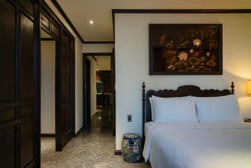 a bedroom with a bed and a painting on the wall at Amanaki Thao Dien in Ho Chi Minh City