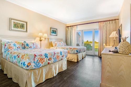 a hotel room with two beds and a window at 256 Sandcastles - Hotel Side in Fernandina Beach
