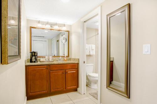 a bathroom with a sink and a toilet and a mirror at 256 Sandcastles - Hotel Side in Fernandina Beach