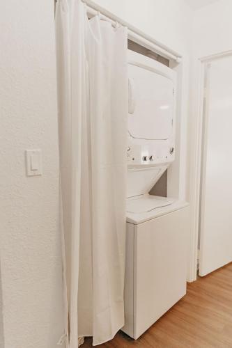 a bathroom with a white shower curtain next to a sink at Puamana Maluhia - Two Bedroom / Two Bath Condo in Princeville