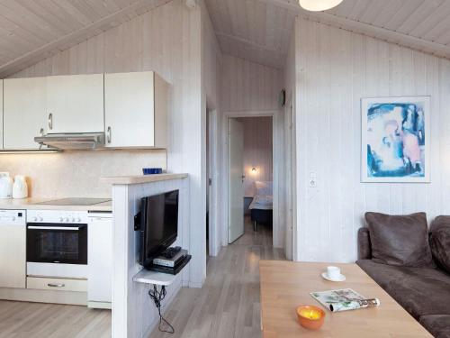 eine Küche und ein Wohnzimmer mit einem Sofa und einem Tisch in der Unterkunft 4 person holiday home in GROEMITZ in Grömitz