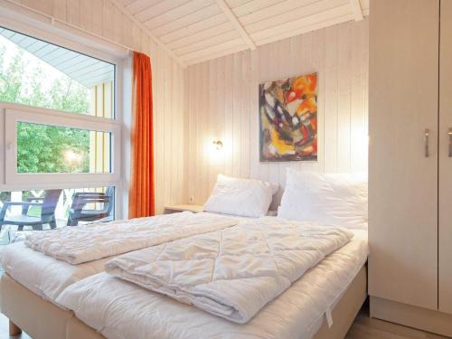 ein weißes Bett in einem Zimmer mit Fenster in der Unterkunft 6 person holiday home in GROEMITZ in Grömitz