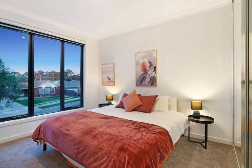 a bedroom with a bed and a large window at Linear Park Living - Brand New 4 Bed Family Home in Thebarton