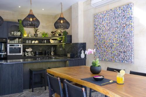 a dining room with a table and a kitchen at Amanputri Villa in Seminyak