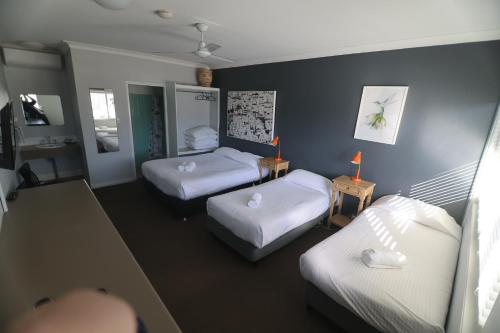a small room with two beds and two beds sidx sidx sidx at Motel Melrose in Mittagong