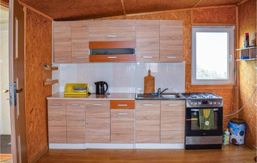 eine Küche mit Holzschränken und einem Herd in der Unterkunft Gorgeous Home In Biskupiec With Kitchen in Biskupiec