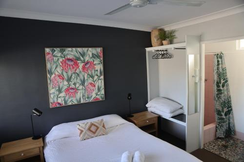 um quarto com uma cama e um quadro na parede em Motel Melrose em Mittagong