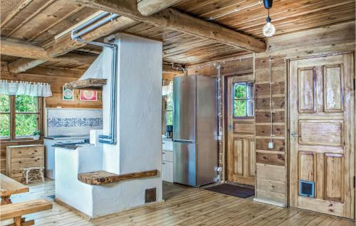 a kitchen with a refrigerator and wooden walls at Awesome Home In Milakowo With 4 Bedrooms in Miłakowo