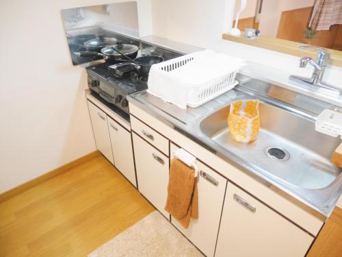 uma cozinha com um lavatório e um fogão em NK　apartment　 em Sapporo