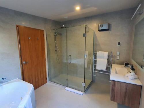 a bathroom with a glass shower and a sink at Luxury Home with Beautiful Lake & Mountain Views in Queenstown