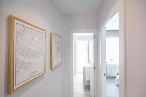 Apartamento Foro Romano في سرقسطة: ممر مع خرائط إطارة على الحائط