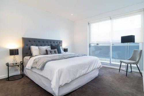 Un dormitorio blanco con una cama grande y una ventana. en Marble CBD Luxury 2 Bedroom Apt Pool & Parking, en Adelaida