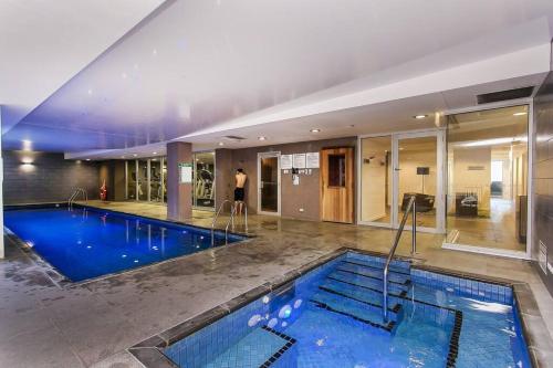 a large swimming pool in a large building at Marble CBD Luxury 2 Bedroom Apt Pool & Parking in Adelaide