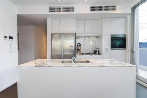 una cocina con fregadero y encimera en Marble CBD Luxury 2 Bedroom Apt Pool & Parking, en Adelaida