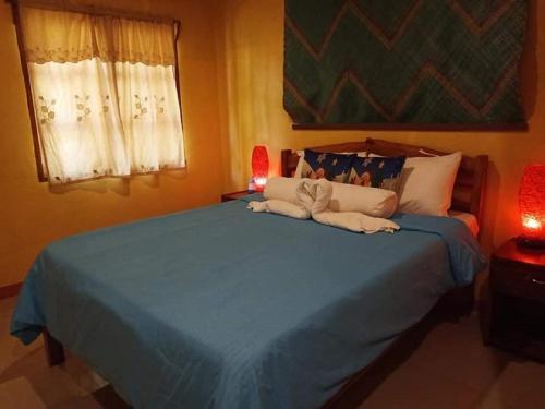 a bedroom with a blue bed with two towels on it at TAGBALAYON Lodging House in Siquijor