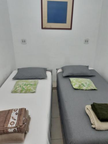 dos camas sentadas una al lado de la otra en una habitación en Kitnet Aconchegante Em Benfica, en Río de Janeiro