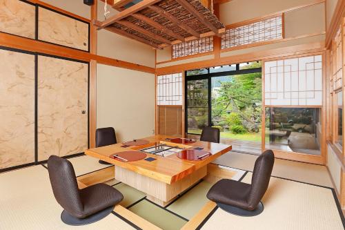 a conference room with a wooden table and chairs at 会津東山温泉　鶴我東山総本山 in Aizuwakamatsu